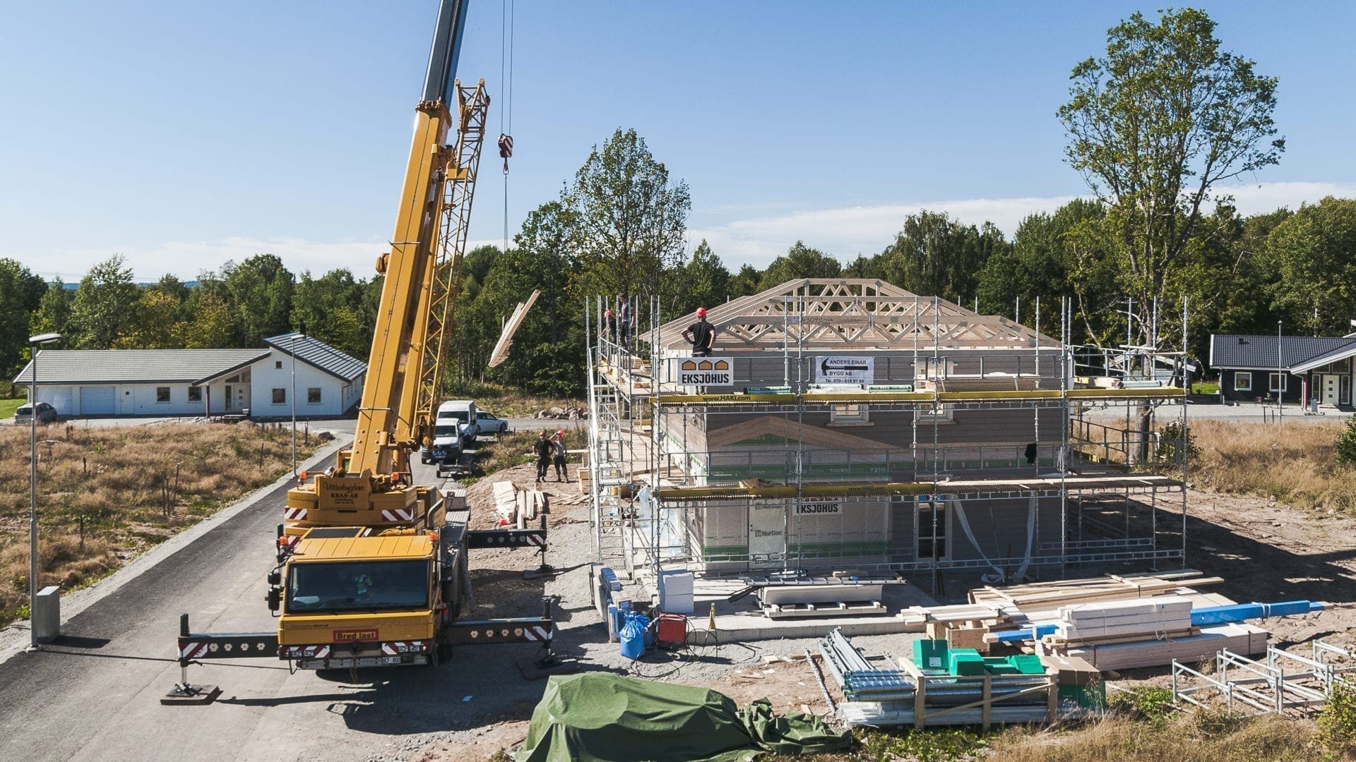 Vy över kranbil som bygger ett nytt hus